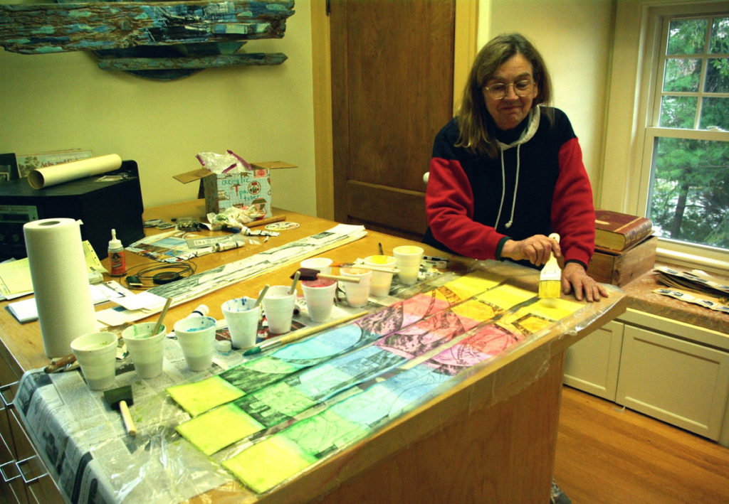 Beth, painting the etching proof strips rainbow colors with translucent acrylic paint.