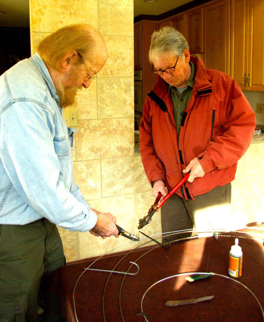 Armature. Bob Neville and Tom Chippendale assist in snipping metal hooks.