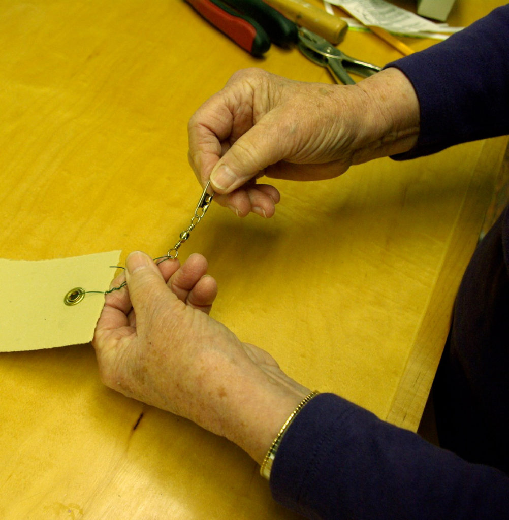 Securing paper strips. Fastening on the swivel snaps made from fishing gear.