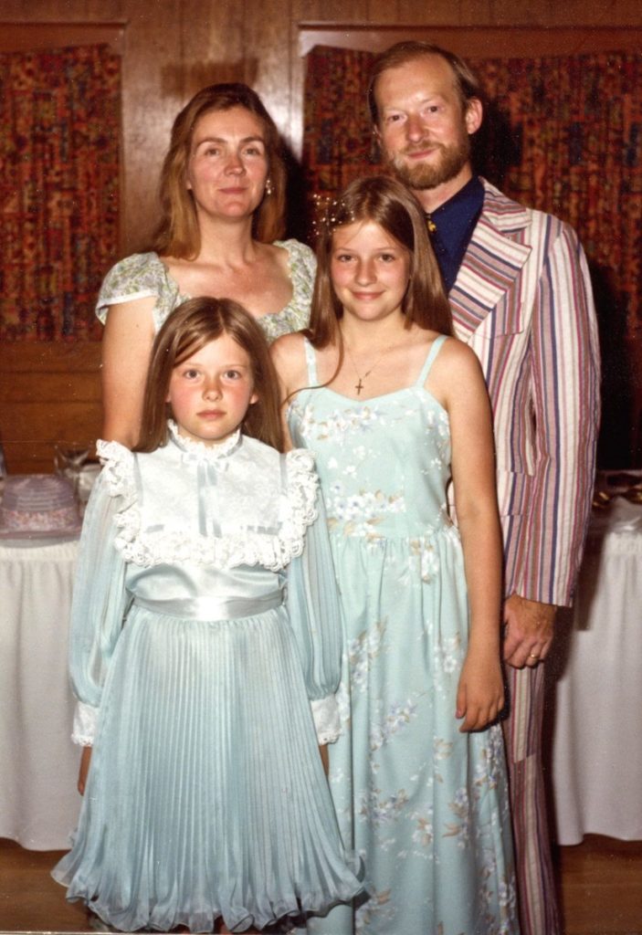 two adults, two children modeling hand-made clothing